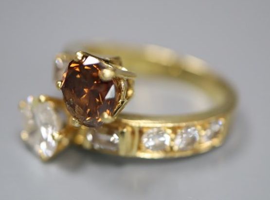A modern yellow metal and two colour diamond two stone crossover ring,